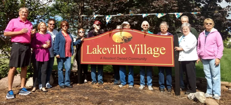 Photo of residents and new signs at community entrances.
