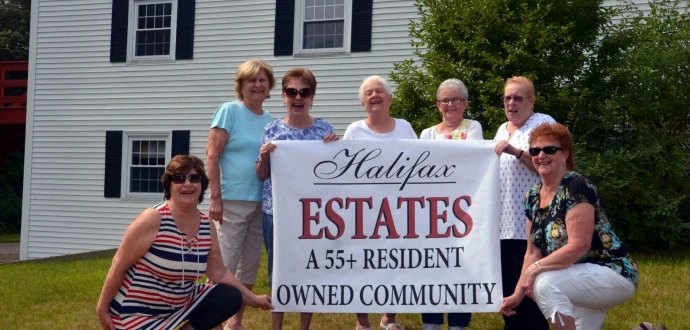 photo of Board Members holding banner displaying community name