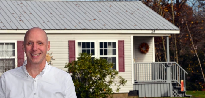 Photo of Paul Bradley in front of a manufactured home in a New Hampshire co-op.