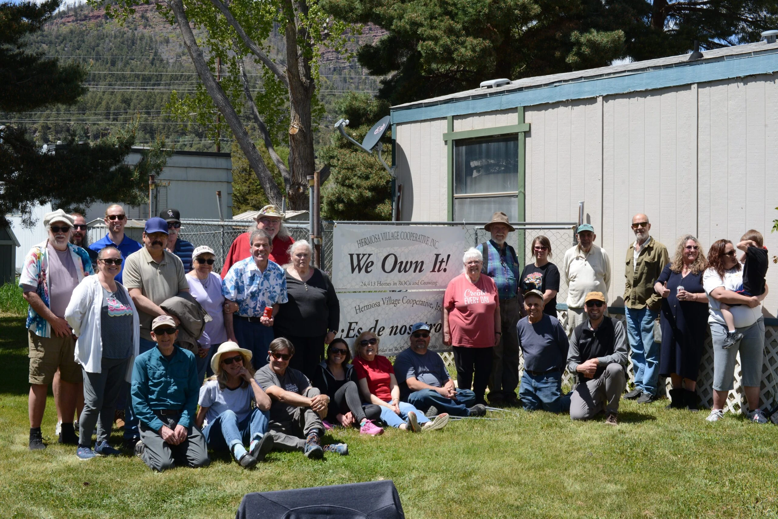 Residents of Hermosa Village Cooperative in Durango, Colorado gather around a banner that says