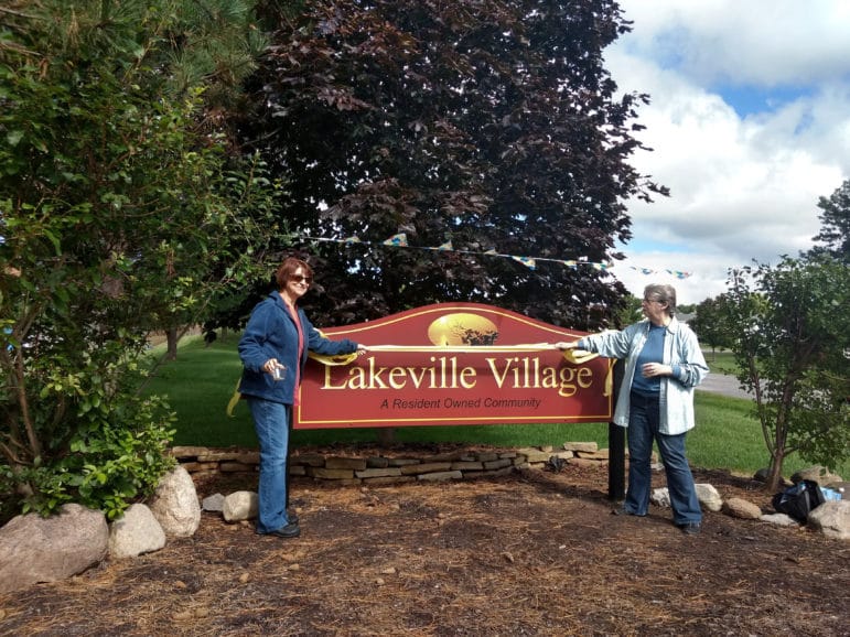 Photo of residents and new signs at community entrances.