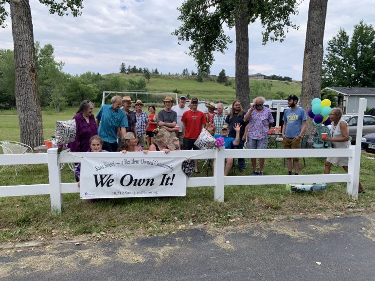 Sans Souci Member-owners pose with a banner proclaiming "We Own It!"